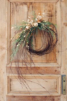 an old door with a wreath and flowers on it