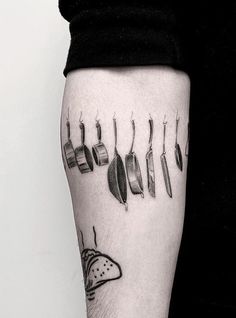 a person with a tattoo on their arm that has different things in the shape of feathers