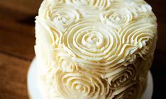 a cake with white frosting sitting on top of a plate