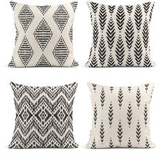 four pillows with black and white designs on them, one in the shape of an arrow