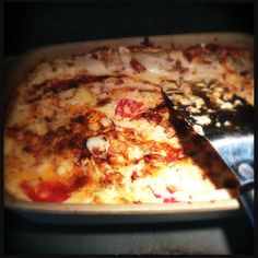 a close up of a pizza on a pan with a knife