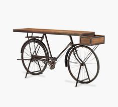 an old fashioned bicycle with a wooden table on the back