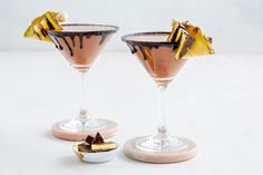 two glasses filled with dessert sitting on top of a white table next to each other