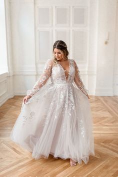 a woman in a white dress standing on a wooden floor