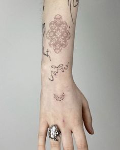 a woman's hand with a small tattoo on the left wrist and right arm