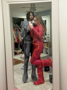 a man and woman are taking a selfie in the mirror while wearing matching costumes