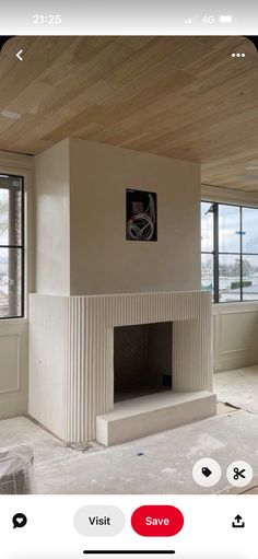 a living room with a fire place in the center and windows on both sides,