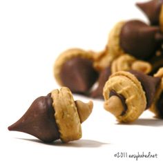 some chocolate and peanut butter treats on a white surface with one cut in half to look like an animal