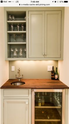 a small kitchen with an oven, sink and cupboards in the wall above it