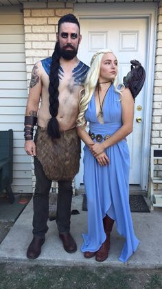 a man and woman in costume standing next to each other on the front steps of a house