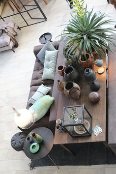 an overhead view of a living room with couches, tables and potted plants