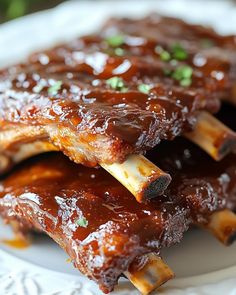 ribs covered in bbq sauce on a white plate