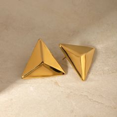 LOVCIA Golden 3D Geometric Stainless Steel Earrings for Women Elevate your style with the exquisite LOVCIA Golden 3D Geometric Stainless Steel Earrings for Women. These earrings are a perfect blend of modern design and timeless elegance, crafted to enhance any outfit with their stunning 3D geometric structure. Key Features: Material: Made with high-quality 18K gold-plated stainless steel, ensuring durability and a luxurious appearance. Design: Intricate 3D geometric design that adds a contempora 3d Pyramid, 3d Triangle, Triangle Earrings Stud, Triangle Studs, Steel Product, Luxury Earrings, Metal Fashion, Waterproof Jewelry, Triangle Earrings