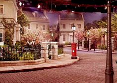 a street scene with focus on the red fire hydrant in the foreground and several white buildings