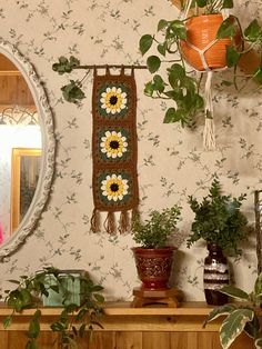 there is a mirror and potted plants on the mantle in this room with wallpaper