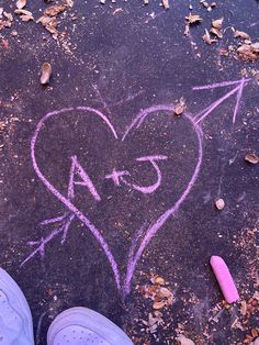 someone's feet standing in front of a heart with an arrow drawn on it