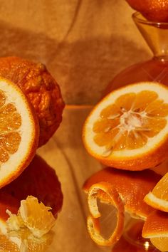 an orange cut in half sitting on top of a table next to other pieces of fruit