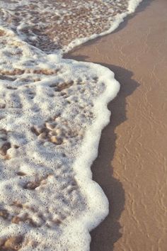 the water is foamy and brown on the beach