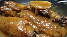 a close up of food in a skillet with sauce on it and a spoon