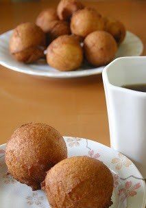 two plates with donuts on them next to a cup of coffee