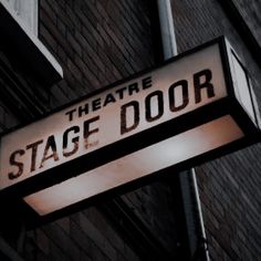 the theatre stage door sign is lit up at night