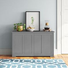 a room with a blue rug and a gray cabinet