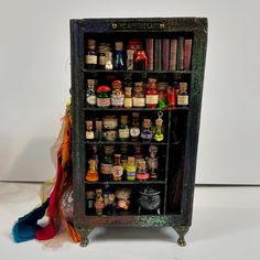 an old book shelf filled with lots of books and spices on top of a white table