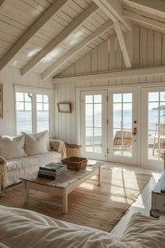 a living room filled with furniture next to an open door leading to the beach side