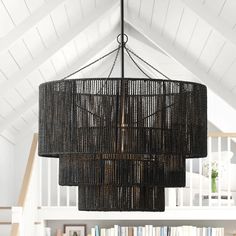 a black chandelier hanging from the ceiling in a room with bookshelves