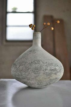 a white vase sitting on top of a table