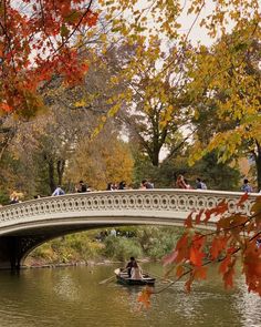 people are riding on a boat under a bridge