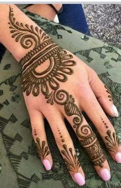 a woman's hand with henna tattoos on it