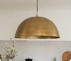 a large brass dome light hanging over a kitchen counter