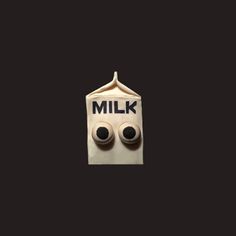 a white bag with two black eyes on it and the words milk in front of it