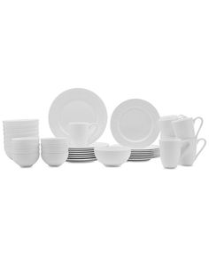 white dishes and cups are stacked on top of each other in front of a white background