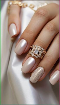 a woman's manicured nails are adorned with gold and diamond accents, while the ring sits on her finger