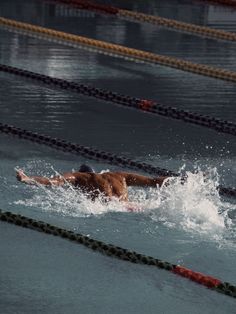 a man swimming in the water with no shirt on and his arm extended out as he swims