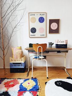 a room with a desk, chair and rug on the floor in front of it