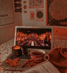 an open laptop computer sitting on top of a table next to a cup of coffee