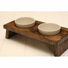 two white bowls sit on a wooden stand