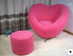 a pink heart shaped chair and foot stool in a living room with white rugs