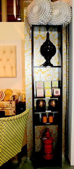 a display case in the corner of a room with yellow and white wallpaper on it