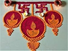 an intricately decorated wall hanging made from red and orange thread with candles on it