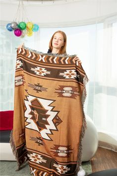 a woman is holding up a blanket in her living room