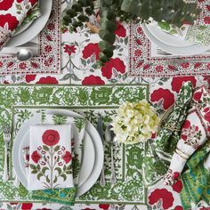 a place setting with red and green flowers