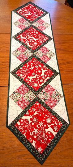 a red and white table runner on top of a wooden floor