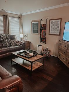 a living room filled with furniture and a flat screen tv on top of a wooden table