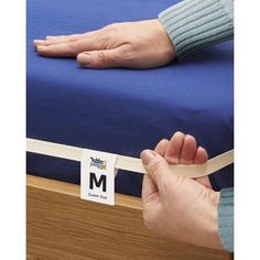 a person is holding onto a mattress with the label on it