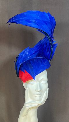 Looking for the perfect headpiece to complete your outfit for an upcoming wedding, band, races or Royal Ascot event? Look no further than this stunning handmade feather fascinator hat in vibrant royal blue and striking Scarlett red. Crafted with care and attention to detail, this fascinator features a beautiful arrangement of feathers that gracefully curve upwards to create an elegant and sophisticated look. The use of contrasting colours adds depth and dimension to the fascinator, making it a t Luxury Blue Headpieces For Races, Blue Structured Crown Headpiece For Party, Red Structured Crown Headpiece For Party, Red Headpiece With Structured Crown For Party, Red Structured Crown Costume Hat For Party, Fitted Blue Headpieces With Feathers, Blue Costume Hat For Carnival, Adjustable Blue Costume Hats And Headpieces, Blue Headpieces For Carnival