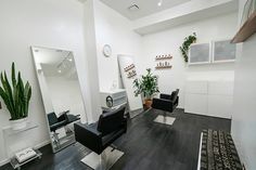 a hair salon with black chairs and plants